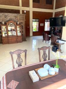 a living room with two chairs and a table with plates at Imogen Yogyakarta in Yogyakarta