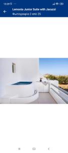 um quarto branco com um sofá branco e uma janela em LEMONIA STUDIOS&SUITES em Agia Anna (Naxos)