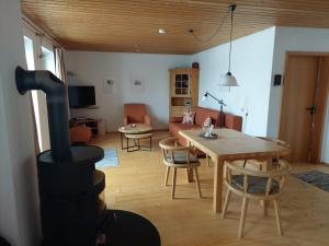 een woonkamer met een houtkachel en een tafel bij Ferienhaus Nienaber in Grafenau