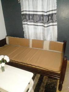eine braune Couch in einem Wohnzimmer neben einem Fenster in der Unterkunft Ikulu house in Mapenya