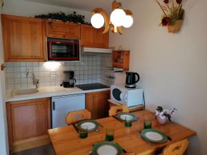 a kitchen with a wooden table with plates on it at Appartement Le Grand-Bornand, 2 pièces, 5 personnes - FR-1-241-164 in Le Grand-Bornand