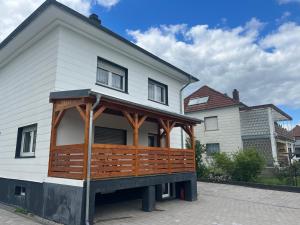 une maison avec une grande terrasse couverte en bois dans l'établissement Ferienwohnung-Monteurwohnung, à Hombourg