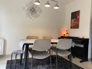 希爾蒂蓋姆的住宿－Maison proximité Strasbourg centre，餐桌、椅子和钢琴