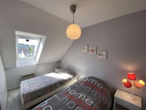 a bedroom with two beds and a window at Appartement vue mer avec parking privé et WiFi à Perros-Guirec - FR-1-542-60 in Perros-Guirec