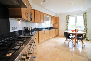 a kitchen with a table and a stove top oven at STYLISH, BEACHSIDE apartment, sea views in St Merryn