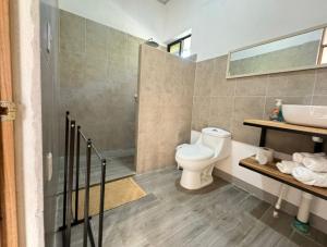 卡維塔的住宿－Serenity Houses，浴室配有卫生间、盥洗盆和淋浴。