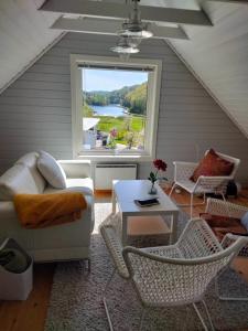 リュングダールにあるAnneks i naturskjønne Gitlevågのリビングルーム(ソファ、テーブル付)、窓が備わります。