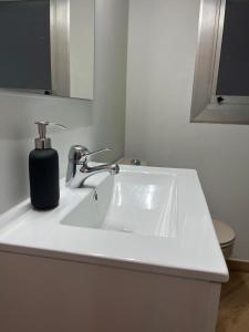 een wastafel in de badkamer met een zeepdispenser bovenop bij Plaza España 238 in Barcelona