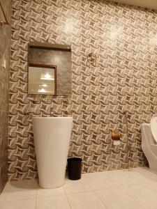 bagno con lavandino e specchio di MZ Hotel and Restaurant Sukkur a Kalar Goth