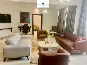 a living room with a couch and chairs and a table at Sopatel Silmandé in Ouagadougou
