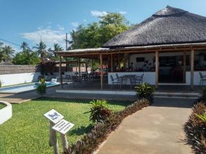 a pavilion with a table and chairs in the grass at Telvina Beach Lodge in Vilanculos