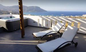 balcone con vasca idromassaggio, sedie e vista sull'oceano di Casa Vista 360 a Karpathos