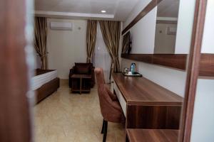 Fabino by Top Rank Hotels في أبوجا: غرفة مع مكتب وسرير في غرفة