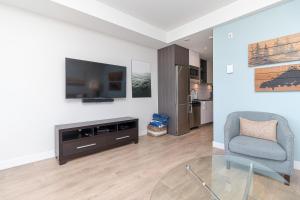 a living room with a tv and a chair at Sunlit Urban Charm In Old Town Victoria in Victoria