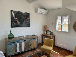 a living room with an old wooden cabinet and two chairs at 2 pièces climatisé en duplex avec terrasse in Aix-en-Provence