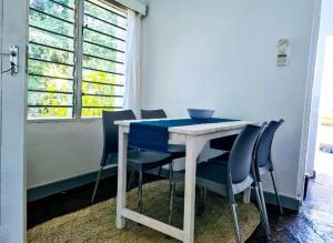 einen Tisch und Stühle in einem Zimmer mit Fenster in der Unterkunft 2 Bedroom Holiday Cottages Bofa Road, Kilifi in Kilifi