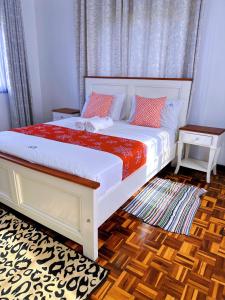 a bedroom with a large bed with red and white sheets at Villa Ella in Mombasa