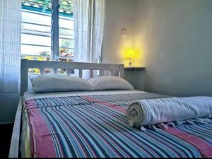 Una cama con una manta a rayas en un dormitorio en 2 Bedroom Holiday Cottages Bofa Road, Kilifi, en Kilifi