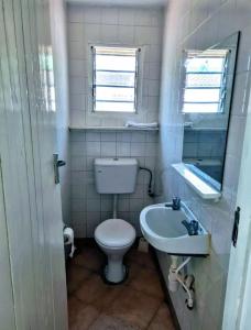 Baño pequeño con aseo y lavamanos en 2 Bedroom Holiday Cottages Bofa Road, Kilifi, en Kilifi