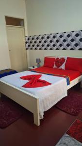 Un dormitorio con una cama con una flor roja. en Casa de Férias en Tarrafal