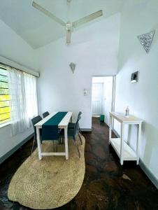 キリフィにある2 Bedroom Holiday Cottages Bofa Road, Kilifiのテーブルと椅子、天井ファンが備わる客室です。