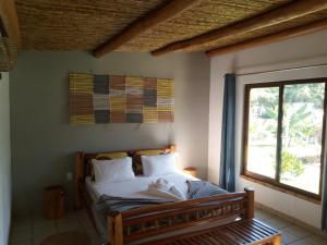 a bedroom with a bed with a window in it at Telvina Beach Lodge in Vilanculos