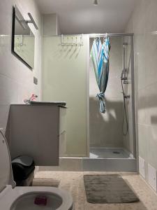 a bathroom with a shower and a toilet with an umbrella at Angel in Lens