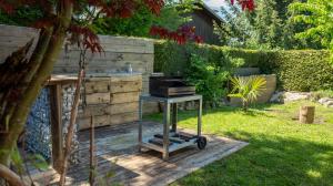 een grill op een stand in een tuin bij Appartement avec Jardin à 10 min d'Annecy in Charvonnex