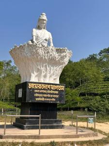 a statue of a woman sitting on top at D'more Sreemangal Hotel & Resort in Sreemangal