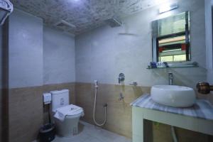 uma casa de banho com um lavatório e um WC em D'more Sreemangal Hotel & Resort em Sreemangal
