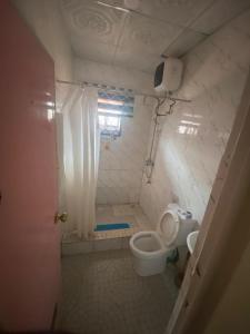 a small bathroom with a toilet and a shower at Biji Paradise Hotel in Benin City
