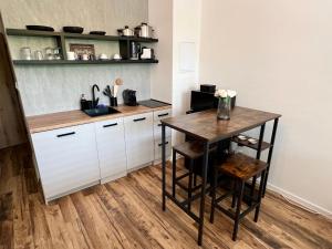 a kitchen with white cabinets and a wooden table at Štýlový apartmán City in Banská Bystrica