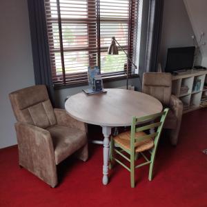 einen Tisch und Stühle in einem Zimmer mit einem Tisch und einem Stuhl in der Unterkunft La Nostra casa in Alblasserdam