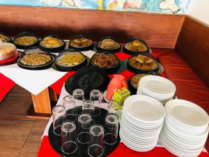un tavolo con un mucchio di cibo e piatti sopra di Hotel Pousada Salvador Paradise a Lauro de Freitas