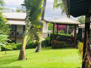 a yard with a gazebo and a palm tree at Hotel Pousada Salvador Paradise in Lauro de Freitas
