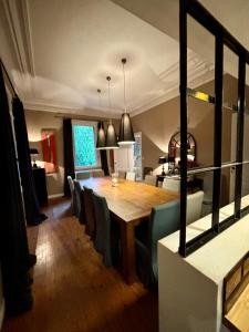 a dining room with a wooden table and chairs at Demeure Arcachonaise de charme in Arcachon