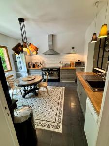 a kitchen with a table and a dining room at Demeure Arcachonaise de charme in Arcachon
