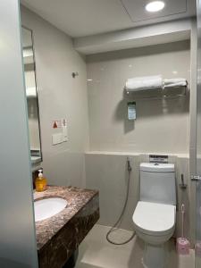 a bathroom with a white toilet and a sink at KK Homestay City Deluxe room - Ming Garden Hotel & Residence in Kota Kinabalu