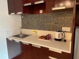 - un comptoir de cuisine avec évier et four micro-ondes dans l'établissement KK Homestay City Deluxe room - Ming Garden Hotel & Residence, à Kota Kinabalu