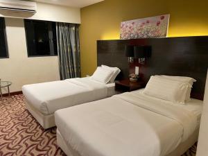 Gulta vai gultas numurā naktsmītnē KK Homestay City Deluxe room - Ming Garden Hotel & Residence