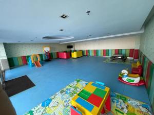 Habitación grande con sala de juegos con muebles coloridos. en KK Homestay City Deluxe room - Ming Garden Hotel & Residence en Kota Kinabalu