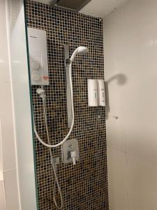um chuveiro na casa de banho com uma parede em azulejo em KK Homestay City Deluxe room - Ming Garden Hotel & Residence em Kota Kinabalu