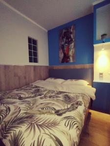 una camera da letto con un letto grande con una parete blu di 1 комнатная квартира в центре a Taraz