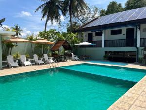 a swimming pool with a house with a solar roof at Hotel Randiya Anuradhapura in Anuradhapura