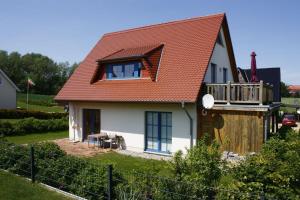 una pequeña casa blanca con techo rojo en Ferienwohnung Johanna EG en Wohlenberg