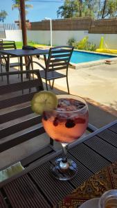 uma bebida sentada numa mesa ao lado de uma piscina em Telvina Beach Lodge em Vilanculos