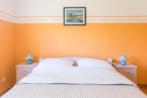 a bedroom with an orange wall with a bed and two night stands at Ferienwohnung Katharina EG in Wohlenberg