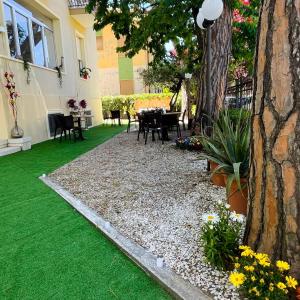 a garden with a table and chairs and a tree at Hotel Villa Pozzi in Cattolica