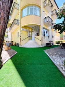 a house with a green lawn in front of it at Hotel Villa Pozzi in Cattolica