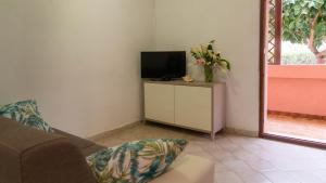 ein Wohnzimmer mit einem TV und einem Sofa in der Unterkunft Casa Ficus in Porto Ottiolu